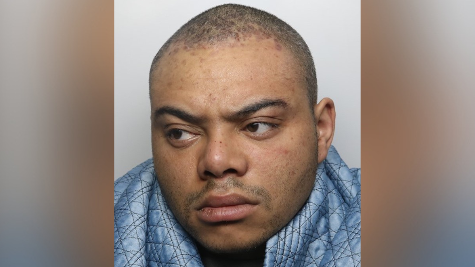 A mug shot of Lewis Wilson who is looking away from the camera