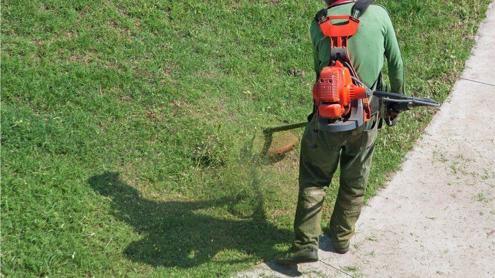 A man using a grass strimmer