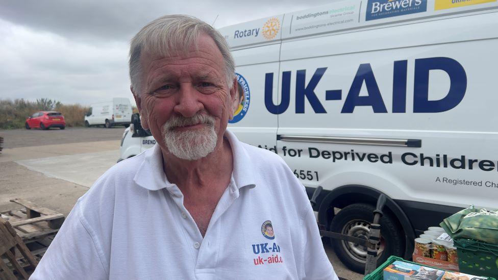 Alan Hilliar in front of a UK-Aid van. 