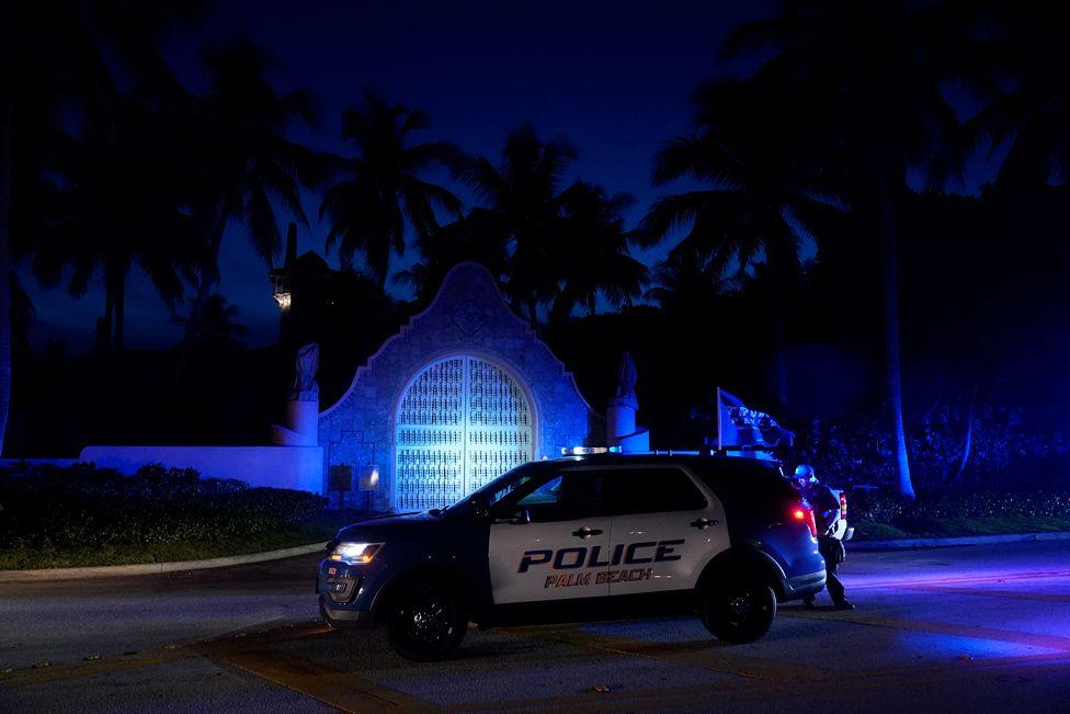 Police stand outside an entrance to former President Donald Trump's Mar-a-Lago estate, Monday, Aug. 8, 2022, in Palm Beach, Fla. as FBI conduct a search  