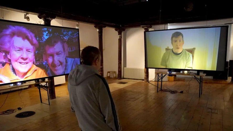 Gary Thomas standing in front of the video installation.