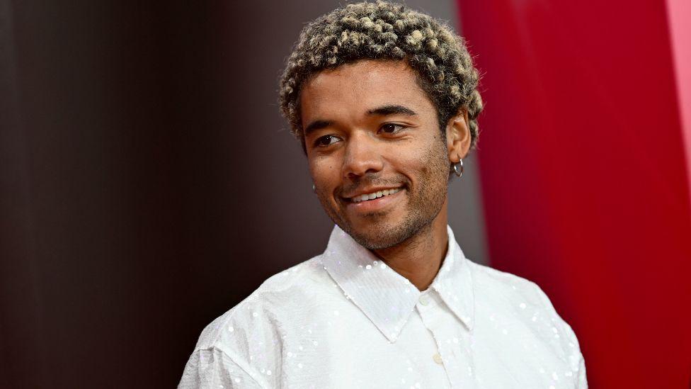 Brandon Wilson attends the Nickel Boys special screening during the 68th BFI London Film Festival at The Royal Festival Hall, he is wearing a white sparkly shift.