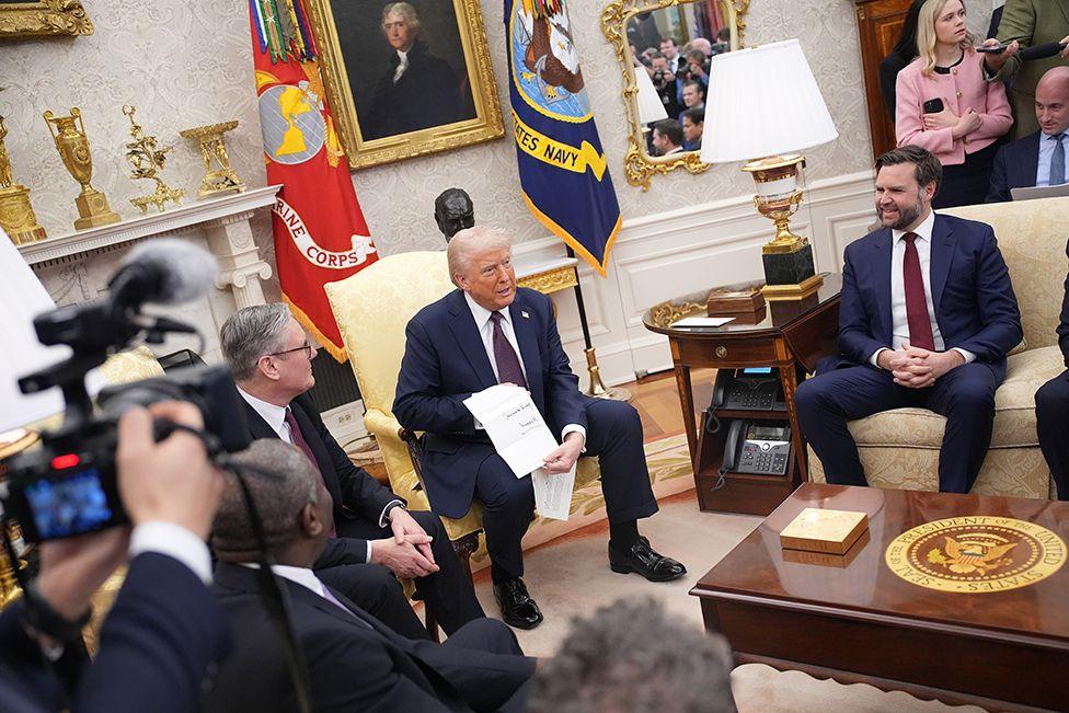 British Prime Minister Keir Starmer (L) presents a letter from King Charles III to U.S. President Donald Trump as Vice President JD Vance (R) looks on in the Oval Office at the White House on February 27, 2025 in Washington, DC. 