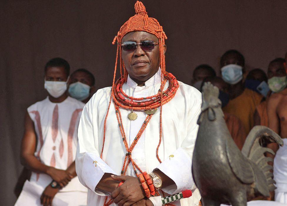 Oba Ewuare II in royal regalia by Benin Bronze cockerel that was returned