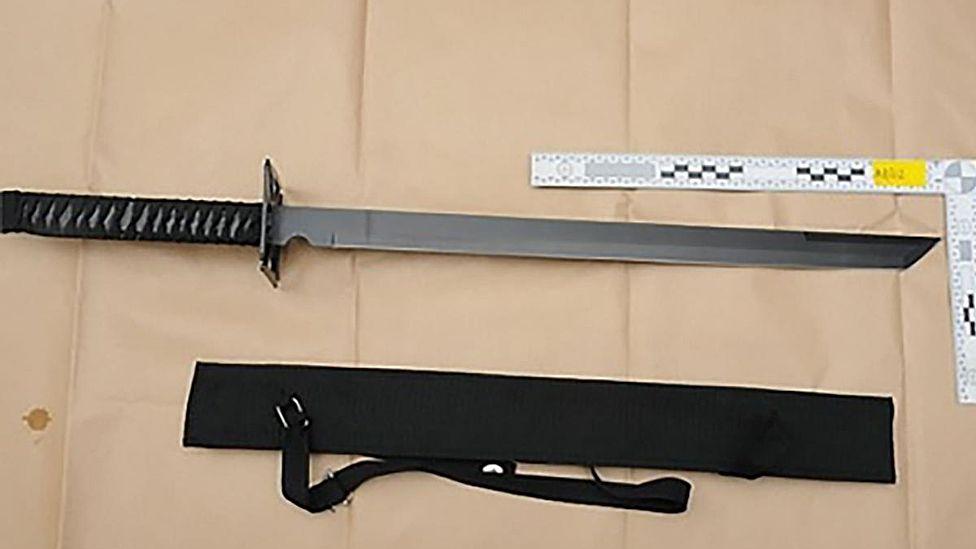 A straight-edged ninja sword next to a sheath