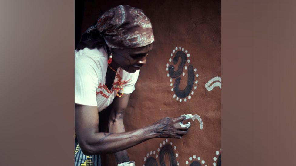 A woman paining a wall