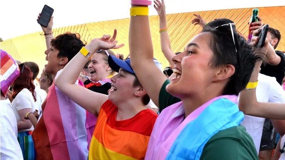 People at a previous Colchester Pride dancing, smiling and holding their mobile phones in the air