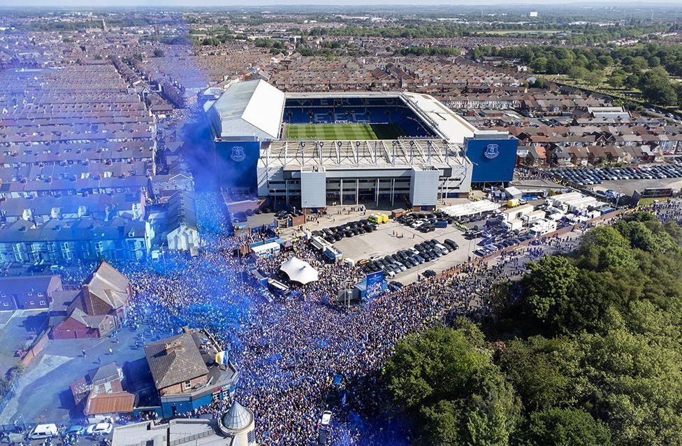 A spectacular aerial view of Goodison Park as fans gather on roads outside and set off blue smoke flares before the men's team's last ever game at the stadium. Photo by Simon Stacpoole/Offside
