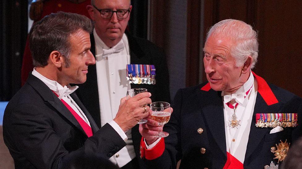 Emmanuel Macron (left) and King Charles clink glasses in a toast