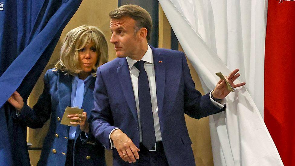 French President Emmanuel Macron and his wife Brigitte Macron exit voting booths at a polling station in Le Touquet-Paris-Plage, France, on 9 June 2024