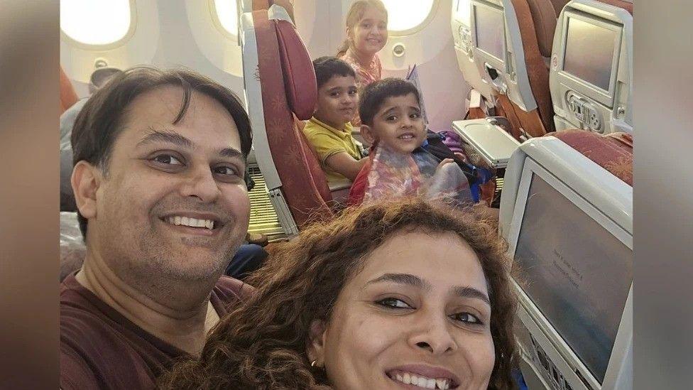 Dr Prateek Joshi (L) takes a selfie with his wife and three children on the plane