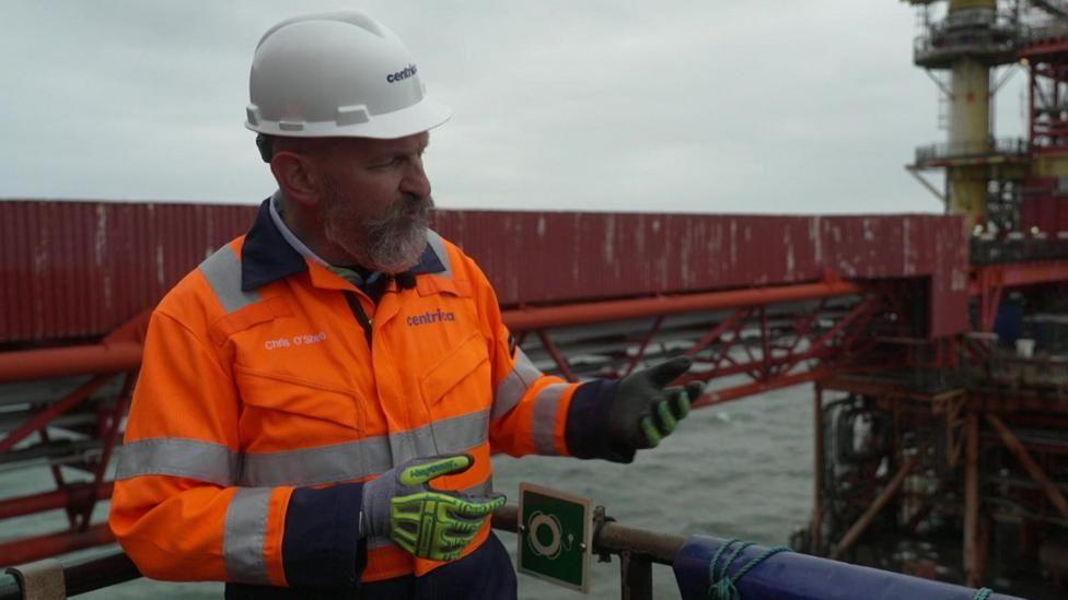 Chris O'Shea wearing a boiler suit on a platform out at sea