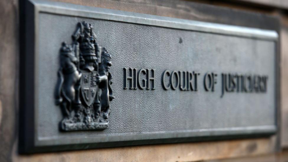 Dark grey sign with words 'High Court of Justiciary'