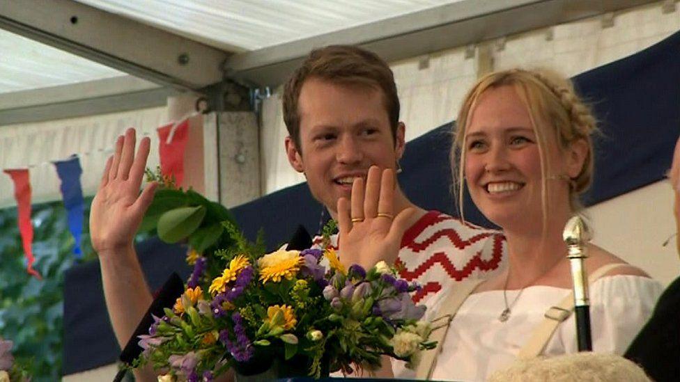 Christopher Atkinson and Meredith Atkinson-Wood holding their hands up