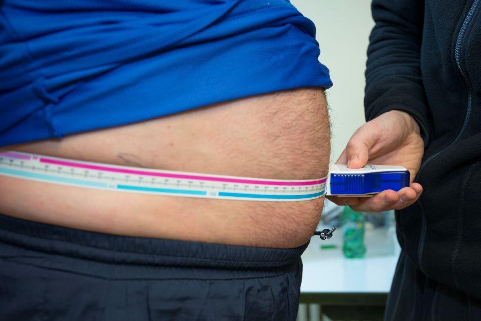 Man's waist being measured