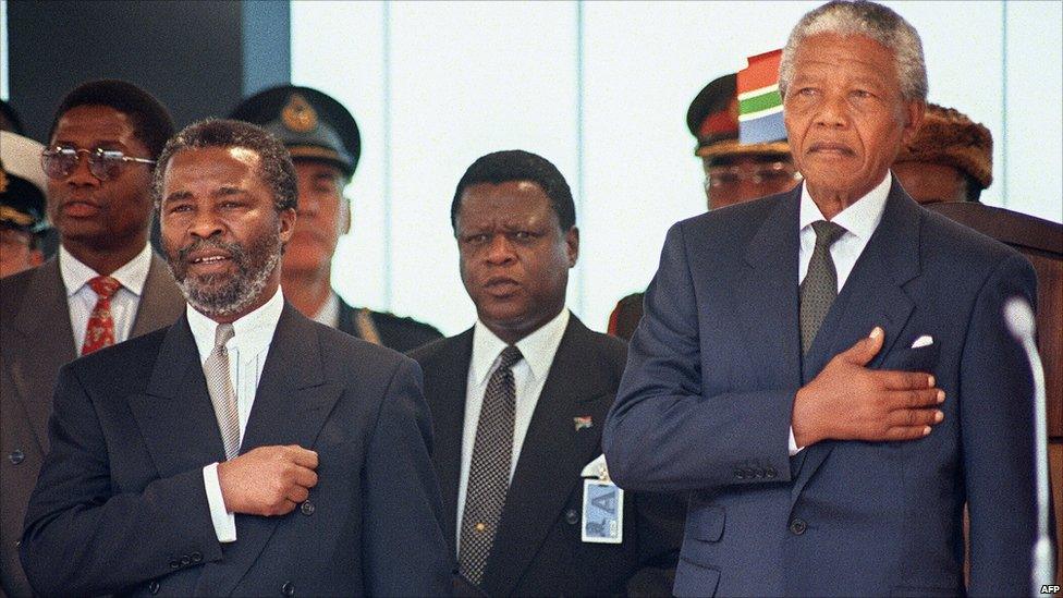 South Africa's new President Nelson Mandela (R) stands at attention as the national anthem is played during his inauguration