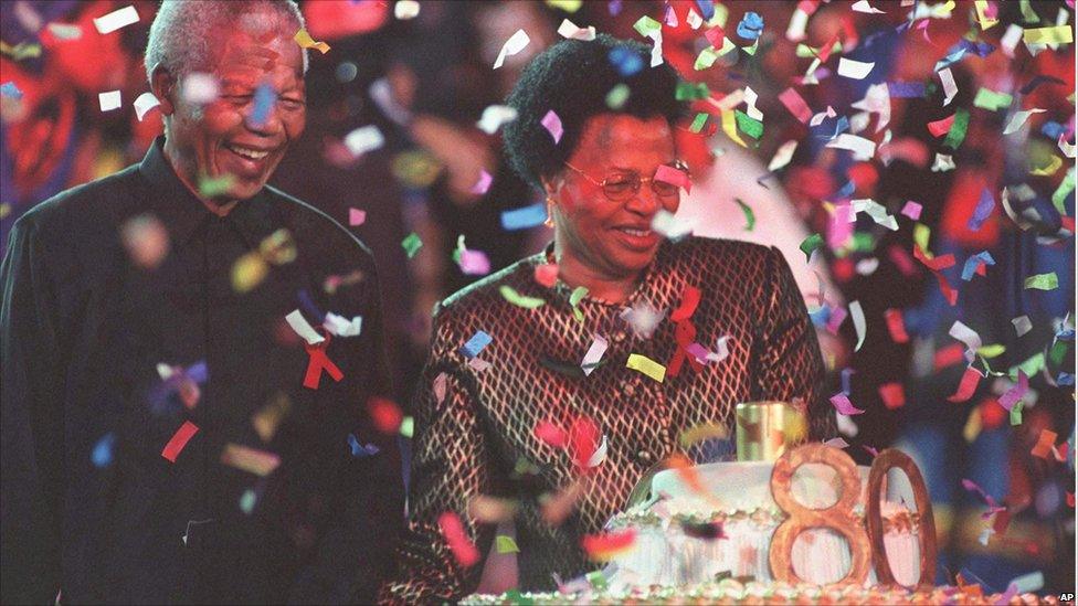 Nelson Mandela with his new wife, Graca Machel, next to his birthday cake, at a reception held at Gallagher Estate outside Johannesburg Sunday, 19 July 1998