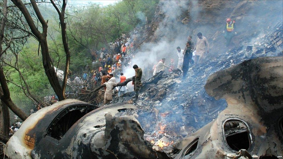 Pakistani rescue workers search for survivors at the crash site