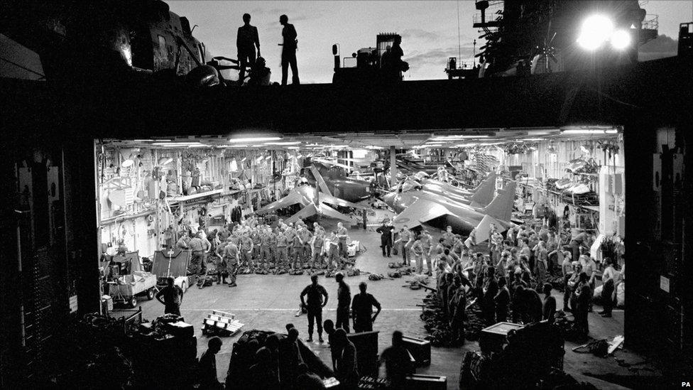 Royal Marines lined up for a weapons check in the hanger of HMS Hermes in the South Atlantic, 1982