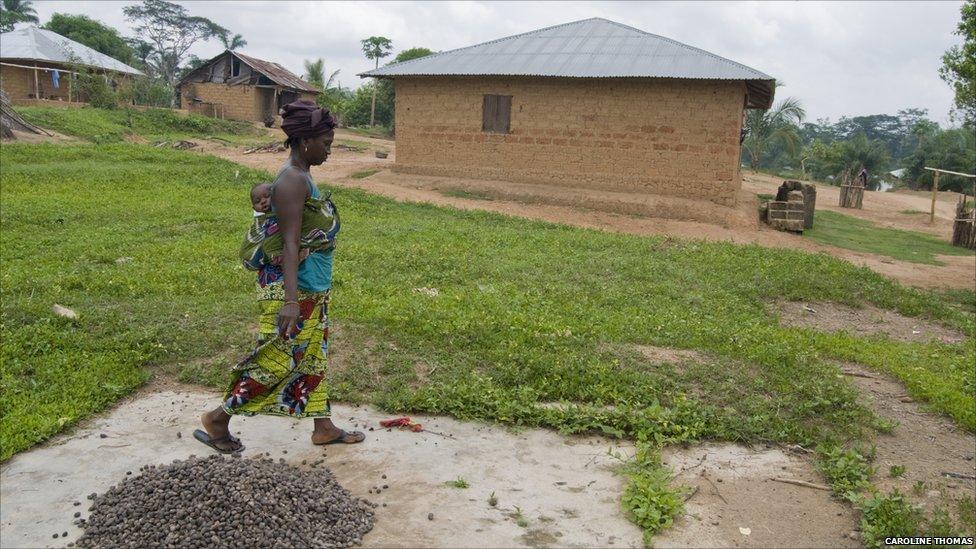 Mama Torma walks on what is left of her old home in the village of Mandopohlun