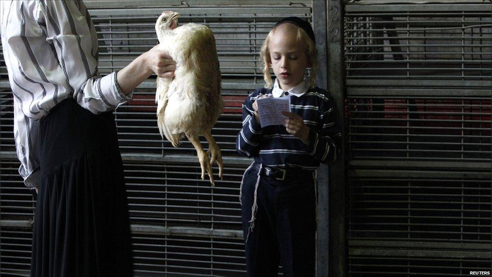 An ultra-Orthodox Jewish woman holds a chicken as her son reads a blessing before performing the Kaparot ritual, ahead of the holiday of Yom Kippur, in Bnei Brak near Tel Aviv on 15 September 2010.