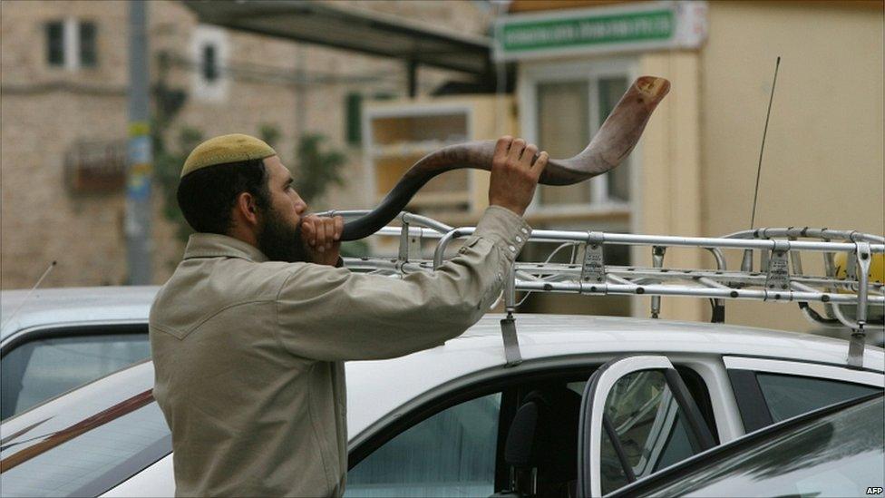 A Jewish settler blows the Shofar horn on the eve of Yom Kippur, near the disputed Ibrahimi mosque, known to Jews as the Tomb of the Patriarchs, during the weekly Muslim Friday prayer in the flashpoint West Bank city of Hebron on 17 September 2010.