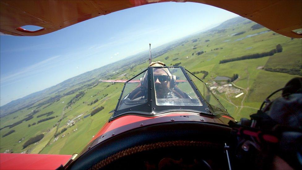 A man in the cockpit of a plane.