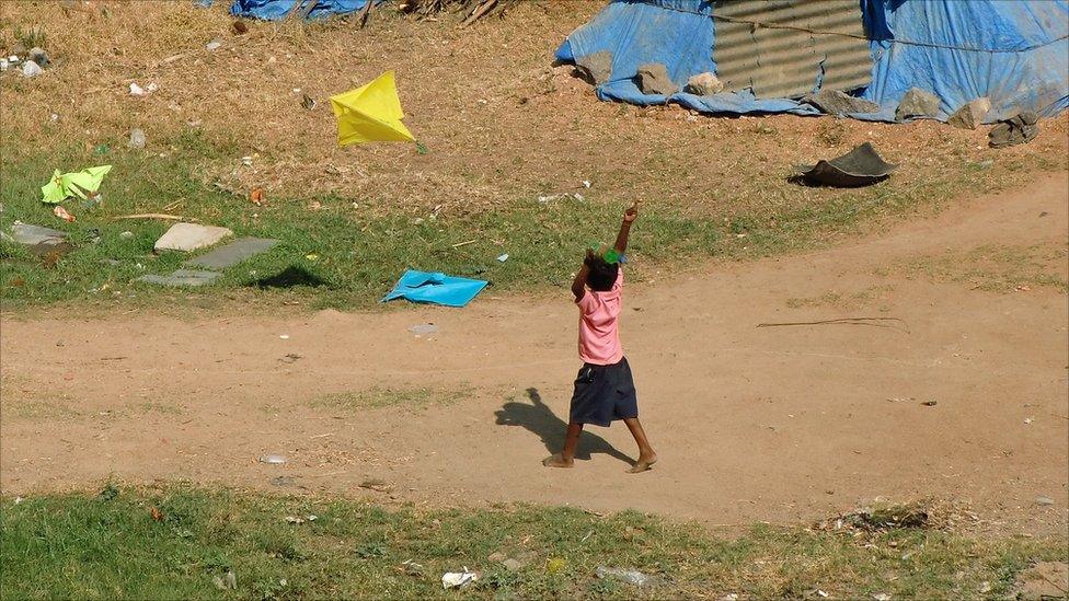 A young boy flying a kite in India