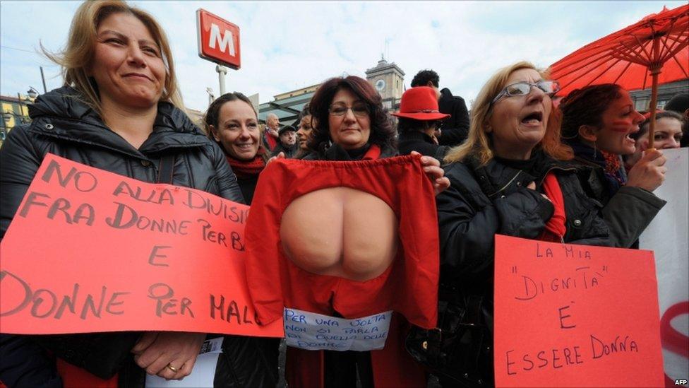 Protesters hold placards in Naples on 13 February 2011