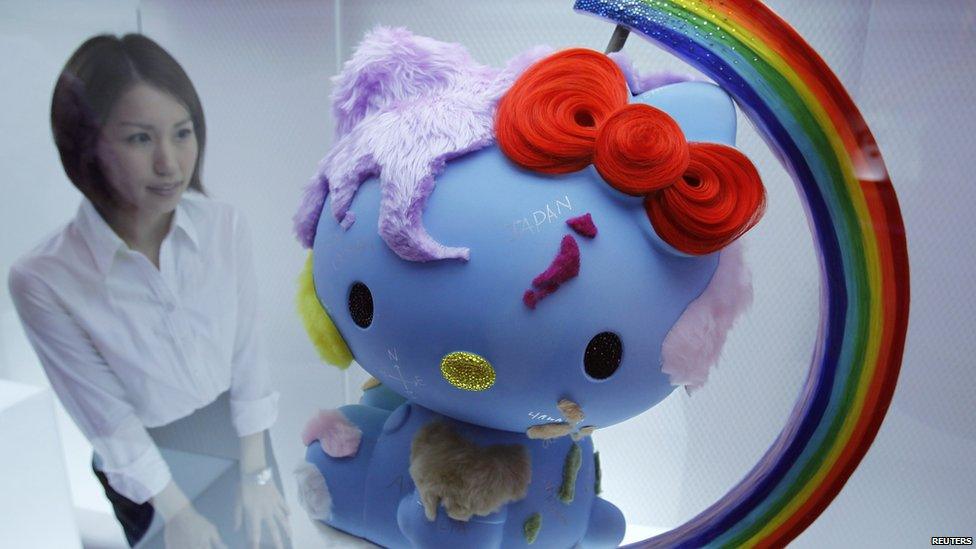 Woman looks at an artwork of Hello Kitty at an event called House of Hello Kitty in Tokyo