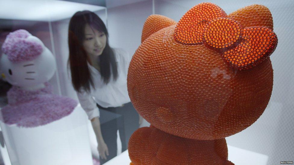 A woman looks at an artwork based on Hello Kitty in Tokyo