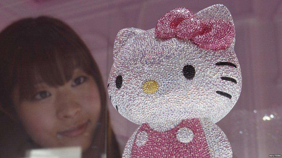 A woman looks at a crystal studded Hello Kitty in Tokyo