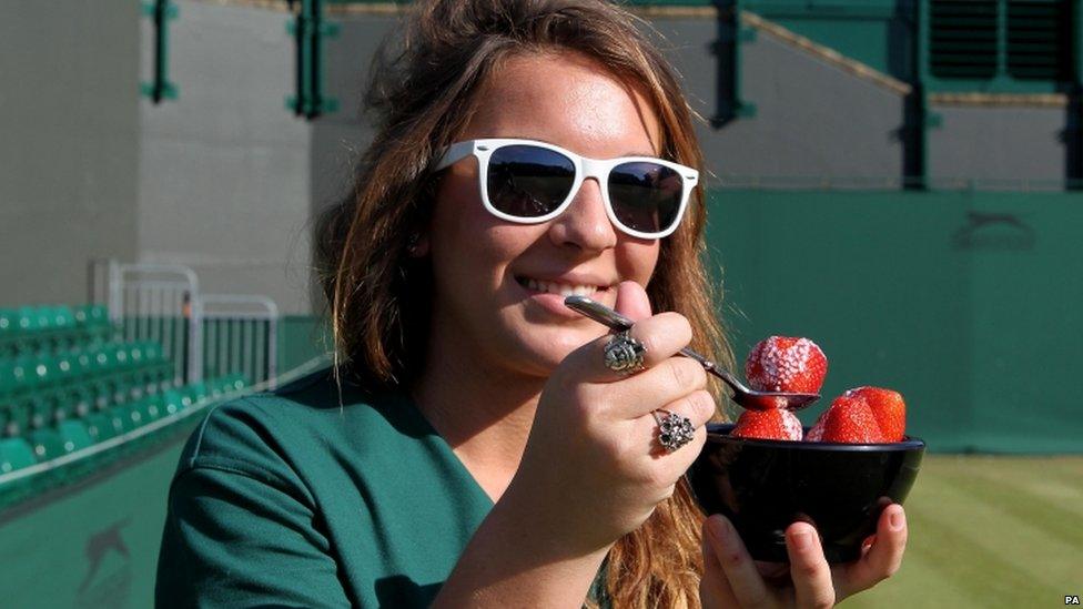 A member of ground staff at Wimbledon eats strawberries