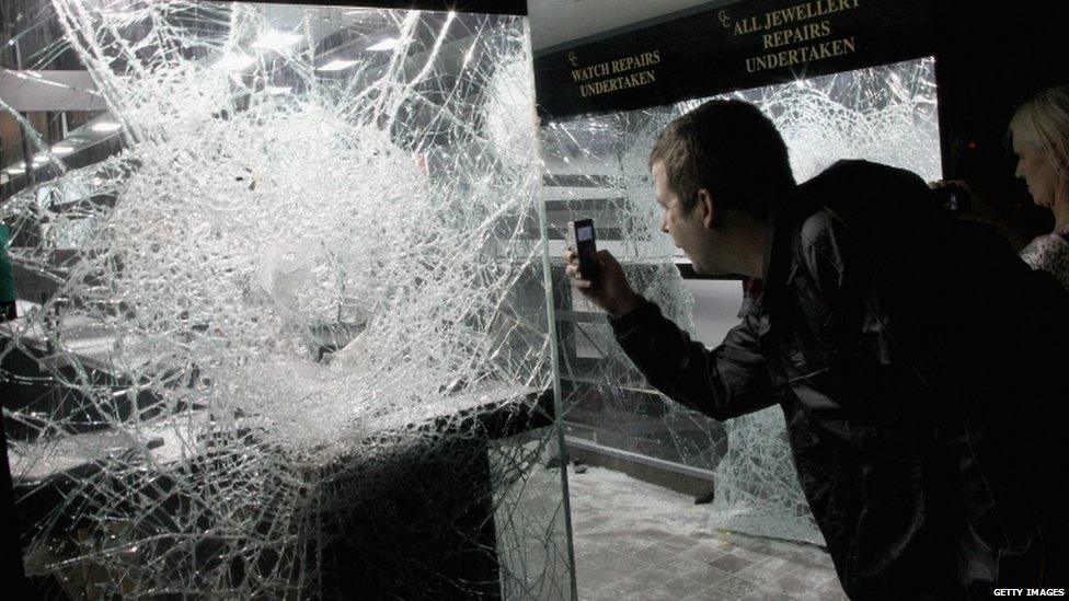 This man photographs a pawn shop that's been ransacked by looters in Clapham, south London