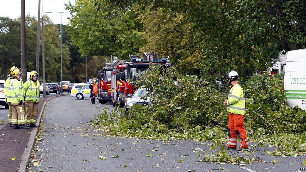 Firefighters tend to trees that have been blown over in Liverpool, north-west England.