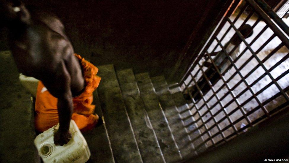 A prisoner carries a carton of water in Liberia's Monrovia Central Prison - 2011