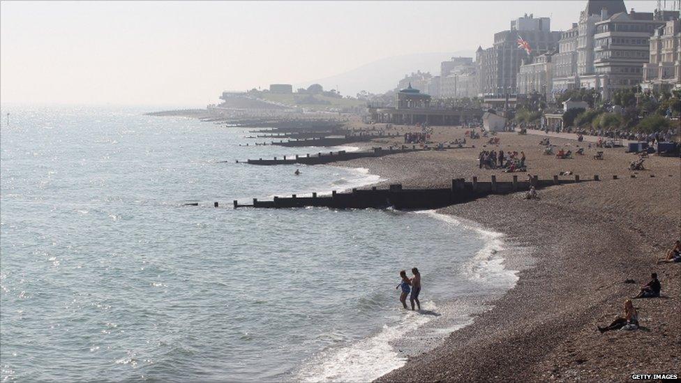 People in the water and on the beach at Eastbourne in south England