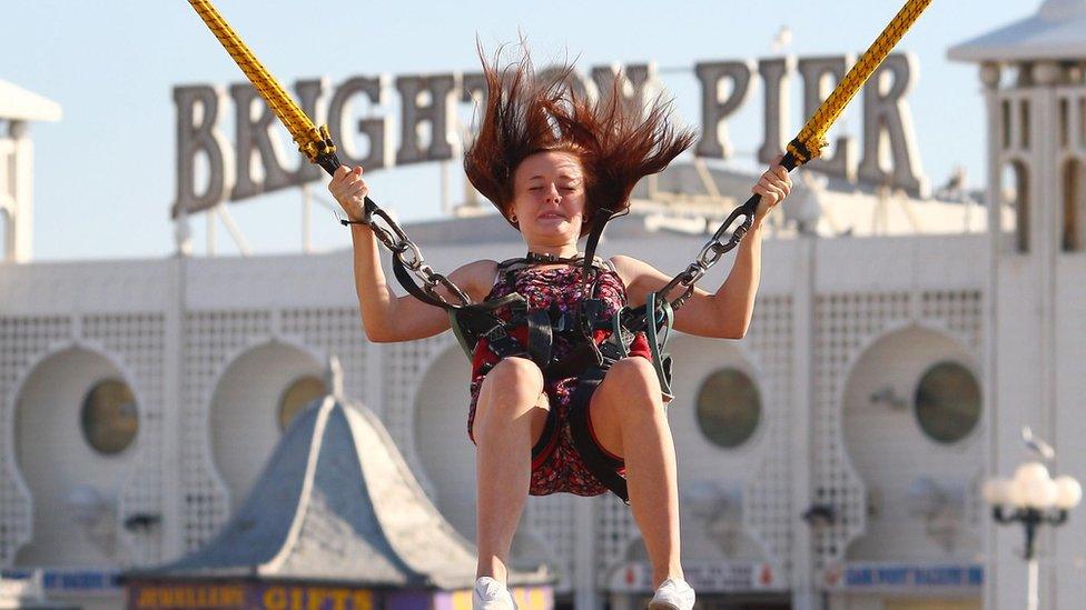 Girl enjoys the Big Air Jump Zone ride in front of Brighton Pier