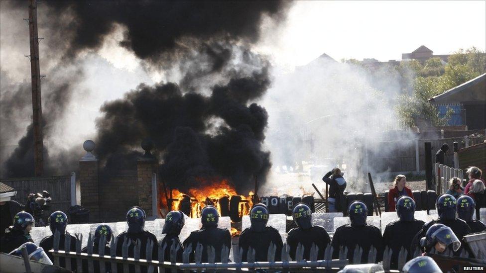 A barricade burns in front of a line of riot police at the Dale Farm Traveller site near Billericay, southern England 19 October 2011