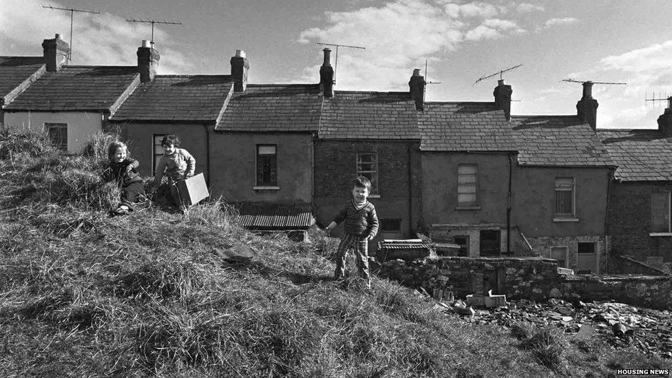 Children play behind homes in Ligoniel in 1975