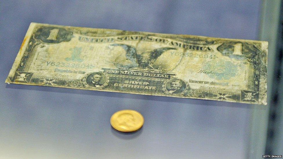 US dollar banknote, soiled with dirt and stains.