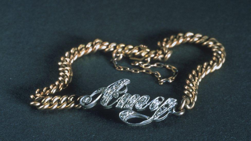 Bracelet with name carved name Amy attached to it.