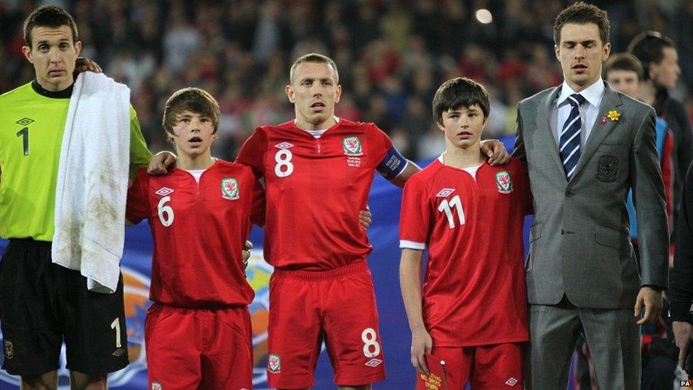 Wales' captain Craig Bellamy and Aaron Ramsey (right) stand alongside Gary Speed's sons Ed and Tommy before the game during the International Friendly at Cardiff City Stadium, Cardiff. Pic: David Davies/PA Wire