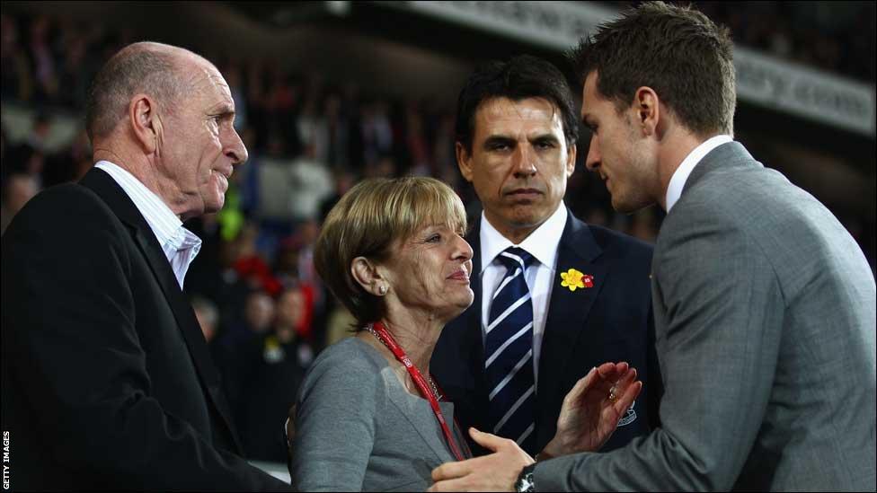 Wales captain Aaron Ramsey greets Gary Speed's parents Roger and Carol ahead of the Gary Speed Memorial Match in Cardiff under the watchful eye of his manager Chris Coleman