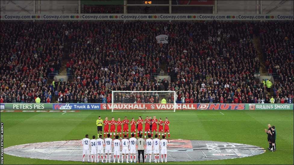 Both Wales and Costa Rica teams line up for the minute applause for the late Wales football manager Gary Speed at the Cardiff City Stadium