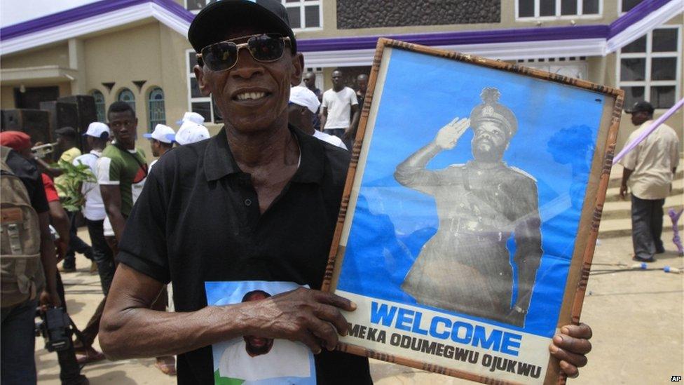 A man holds a picture of Chukwuemeka Ojukwu