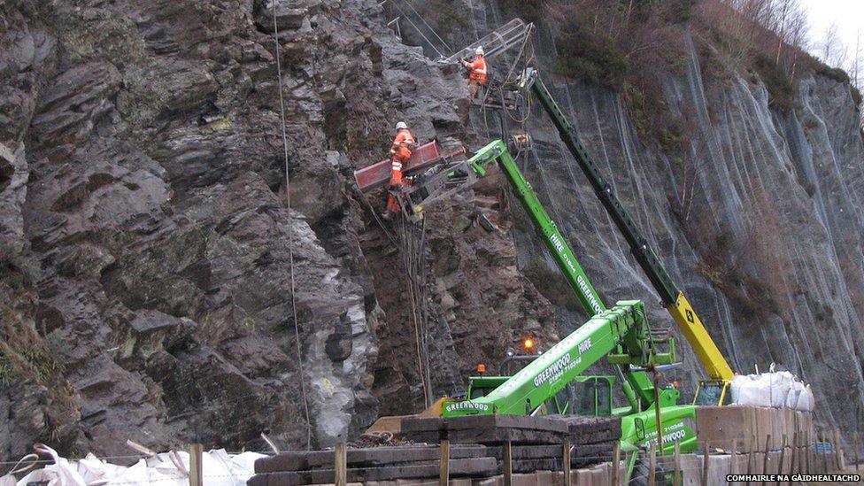 Luchd-obrach aig aghaidh na creige.