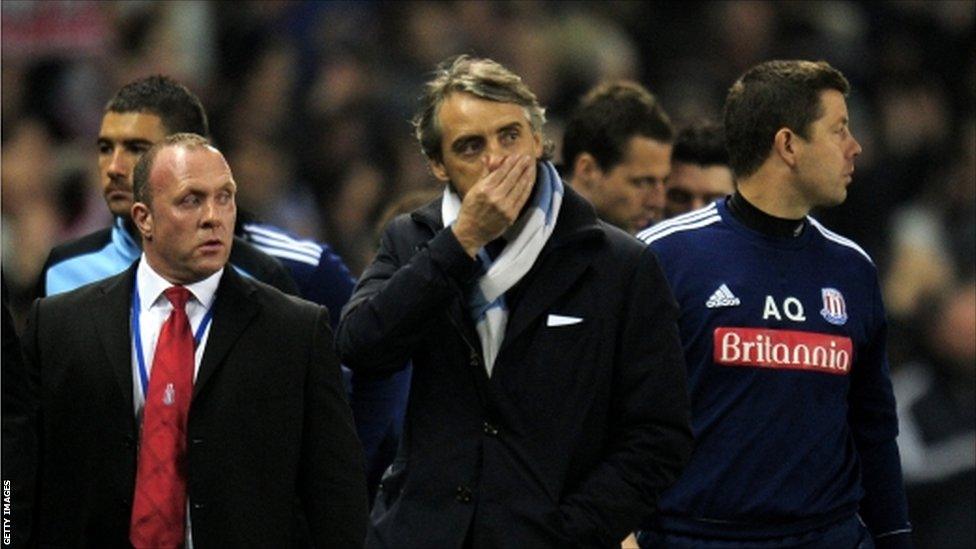 Roberto Mancini the manager of Manchester City walks off the pitch following his team's 1-1 draw against Stoke