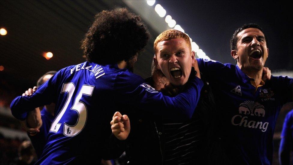 Everton player Tim Cahill (right) and a fan (centre) celebrate Everton's second goal