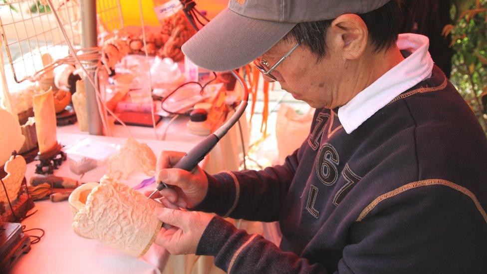 Man carving ornaments out of legal ivory